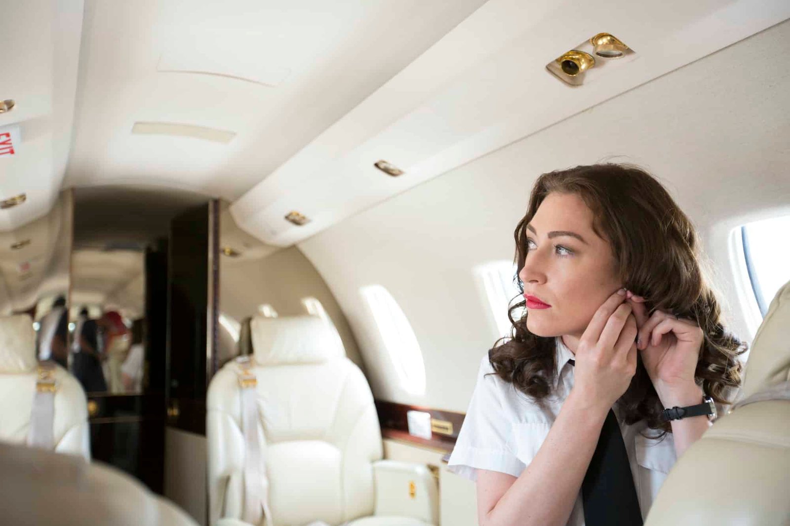 emale-flight-attendant-putting-on-earring-in-cabin-of-private-jet
