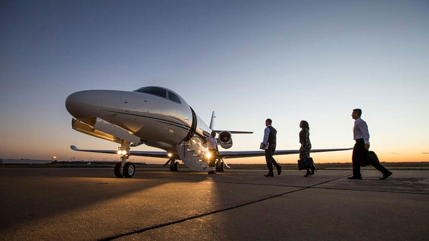 Three people about to enter the private jet
