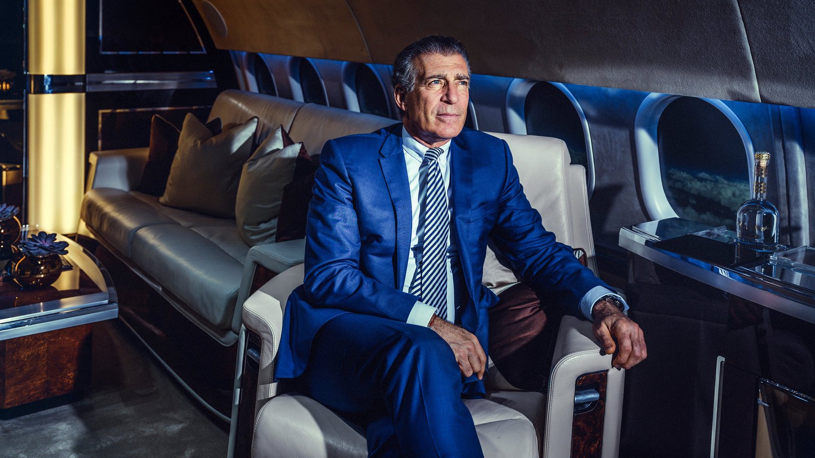 Man in a blue coat sitting inside the private plane