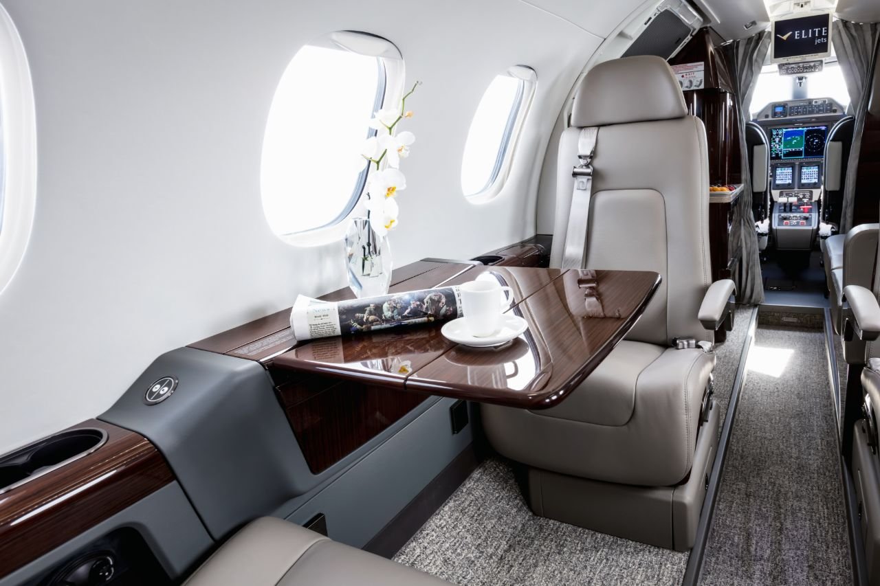 Beautiful interior of a private plane with a white cup and artificial flower on the table