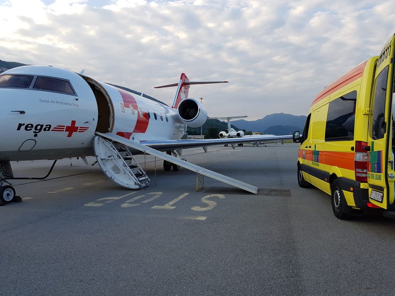 Air ambulance on the airport with a regular road ambulance nearby