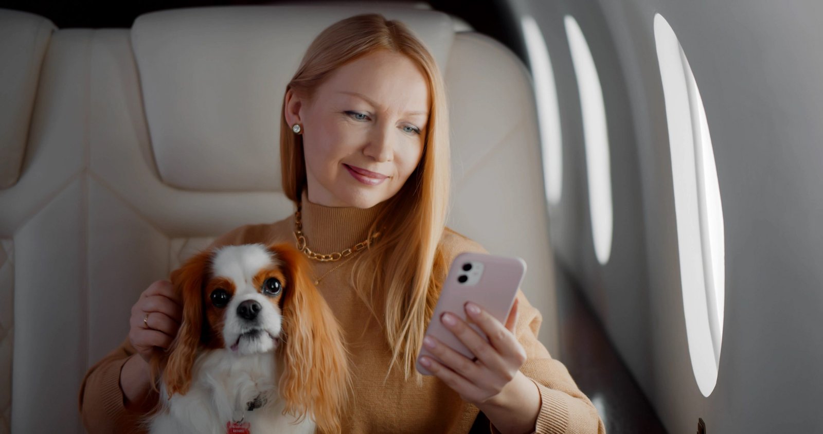 A woman holding a puppy in the charter plane for pets.