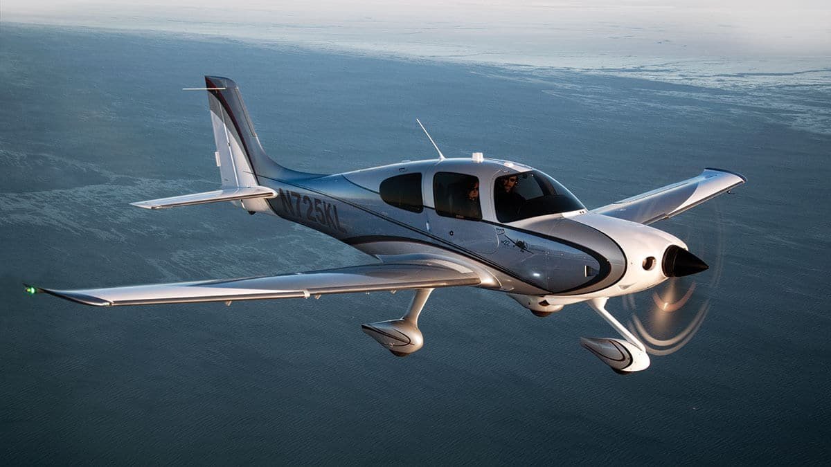 small-private-plane-flying-in-the-sky-with-two-pilots-visible-in-the-cockpit