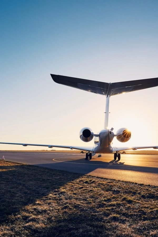 Airport at sunset. Silhouette of private jet against runway.