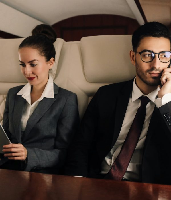 Business team working in private jet, man is talking on smartphone