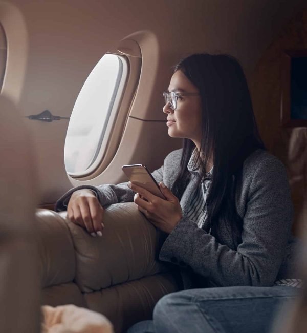 Happy smiling beautiful business woman in private jet