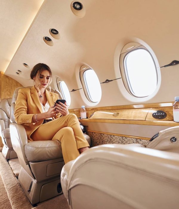 Woman in yellow clothes sits inside of private airplane